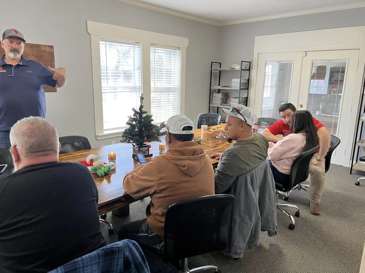 Century Roofing and Construction team members gathered around a conference table